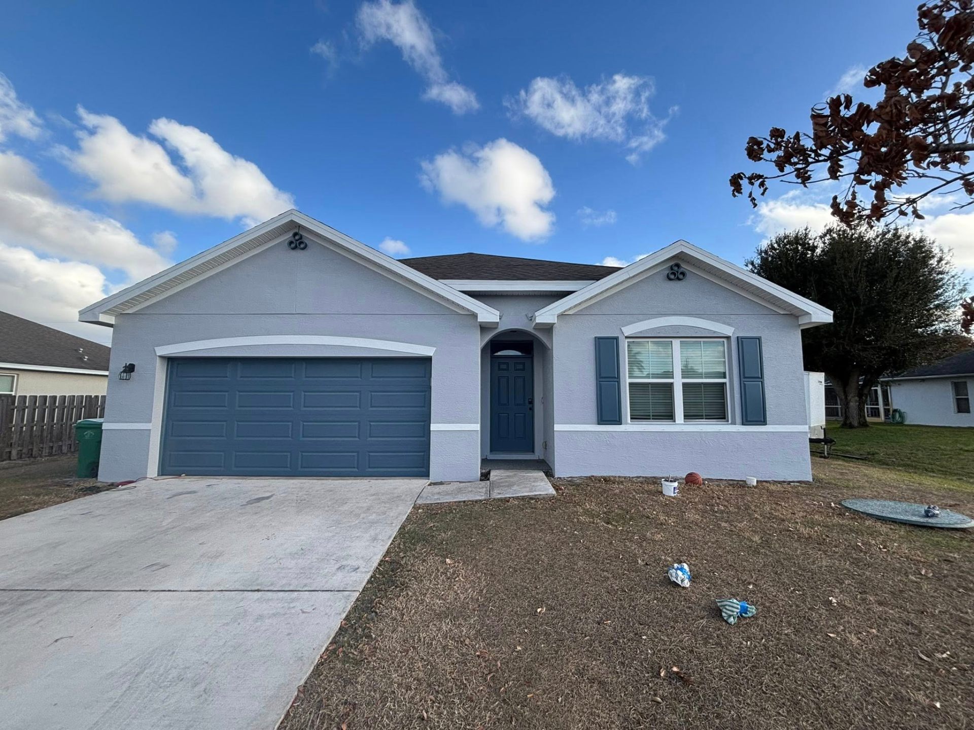 Exterior repaint of a Florida single-story home with blue accents by Millman Services.